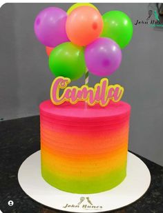 there is a cake that has balloons on it and the name candle spelled in gold