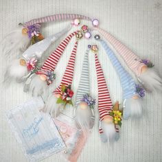 an assortment of colorful hair clips with flowers and feathers on top of a white blanket