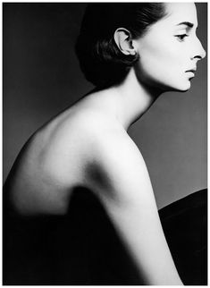 a black and white photo of a woman's back with her hair in a bun