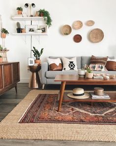 a living room filled with furniture and lots of plants on top of the wall next to a coffee table