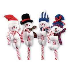 three snowmen are holding candy canes in their hands and one is wearing a top hat