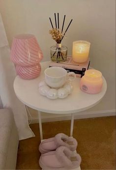 a white table topped with candles and slippers