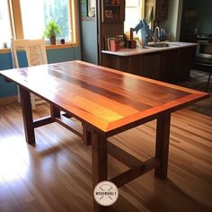 a wooden table sitting on top of a hard wood floor next to a kitchen counter