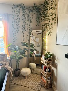 a living room filled with lots of plants next to a window and bookshelf