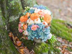 a bridal bouquet sitting on top of a moss covered tree