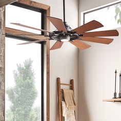 a ceiling fan is hanging in front of a window