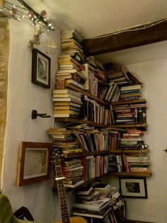 a guitar is sitting in front of a bookshelf full of books and cds