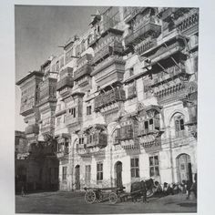 an old building with many balconies and people standing in front of the windows