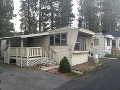 a mobile home sits in front of some trees