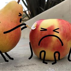 two apples with faces drawn on them, one is biting the other's nose