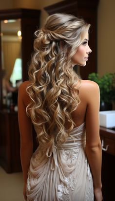 a woman with long, curly hair is standing in front of a mirror wearing a wedding dress