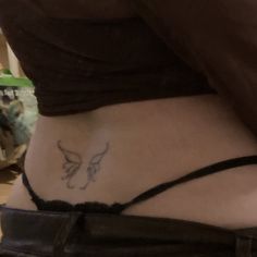 a woman's stomach with a tattoo on her lower back and the bottom part of her abdomen