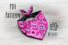 a pink bandana with black polka dots and a dog paw print on the front