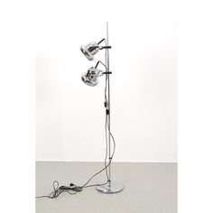 a metal floor lamp with three lamps on it's sides and wires attached to the base