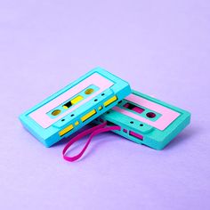 two blue cassette tape recorders sitting next to each other on top of a purple surface