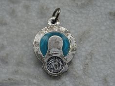 "Religious plique-a-jour silvered medal pendant charm medallion of Holy Virgin Mary and the cave of Lourdes with Saint Bernadette. Measures: 0,67 x 0,68 inches ( 1,71 x 1,74 cm ) Plique-à-jour (French for \"letting in daylight\") is a vitreous enamelling technique where the enamel is applied in cells, similar to cloisonné, but with no backing in the final product, so light can shine through the transparent or translucent enamel. It is in effect a miniature version of stained-glass and is conside Silver Miraculous Medal Pendant, Silver Pendant With Miraculous Medal, Miraculous Medal For Commemoration, Silver Round Pendant For Memorial, Saint Bernadette, The Cave, Virgin Mary, Pocket Watch, Stained Glass