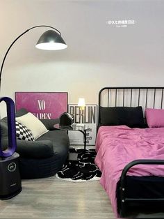 a bed room with a neatly made bed next to a black chair and a lamp