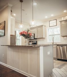 a kitchen with white cabinets and wooden floors