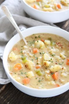 two bowls of soup with crackers on the side