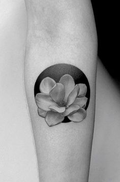 a black and white photo of a flower on the right calf sleeve, with a circle around it