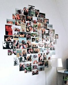 a white wall with many pictures on it and a lamp next to the wall in front of it