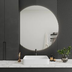 a white sink sitting under a round mirror next to a black cabinet and counter top