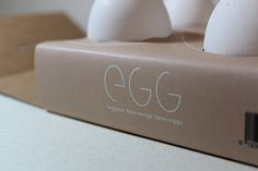 three eggs sitting on top of a box with the word egg printed on it's side