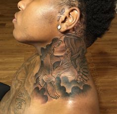 a man with a tattoo on his neck and back is looking up at the sky