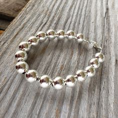 "Beautiful! Classy but simple everyday wear. All shiny round ball 10mm sterling silver bead bracelet. 10mm (LARGE) smooth shiny ball sterling silver beads. 🚩 IMPORTANT IMPORTANT 🚩 10mm are LARGE beads which affects the INSIDE circumference and takes up more room than smaller beads. Please allow a extra room when choosing length. MEASURE WRIST: wrap string around wrist (not tight) and measure end to end. Add about 3/4\" - 1\", depending on your \"comfort\" fit length - loose fit or snug fit. Le Silver Ball Chain Bracelet For Everyday, Silver Beaded Ball Chain Bracelet, Adjustable Sterling Silver Ball Chain Bracelet, Sterling Silver Bracelets With Ball Chain And Round Beads, Sterling Silver Bracelet With Round Spacer Beads For Everyday, Sterling Silver Bracelets With Ball Chain, Silver Beaded Bracelet With Ball Chain As Gift, Silver Beaded Bracelets With Ball Chain, Silver Bracelets With 8mm Beads For Everyday