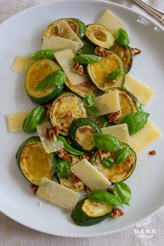 a white plate topped with zucchini and cheese