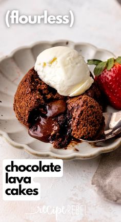 a chocolate lava cake with ice cream and strawberries on the side in a white plate