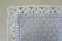 a white crochet doily on top of a table cloth with an intricate design