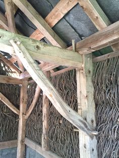 the inside of a building with wooden beams and ropes hanging from it's roof