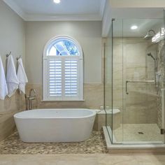 a bathroom with a tub, shower and window