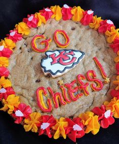 a cookie decorated with icing that says go chiefs on it and is surrounded by flowers