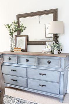 an old dresser is painted blue and has flowers on top