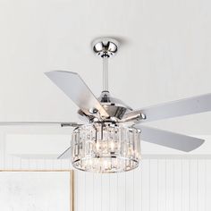 a ceiling fan with crystal chandelier hanging from it's blades in a white room