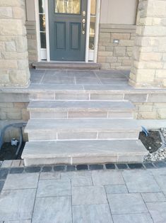 steps leading up to the front door of a house that is being built with stone