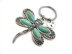 a dragonfly keychain is shown on a white surface