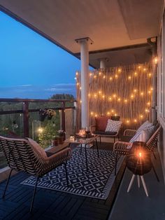 an outdoor patio with string lights and wicker furniture on the deck area, overlooking trees