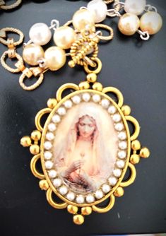 "Captivating Image of the Virgin Mary embellished with Swarovski pearls.  Devotional jewelry handmade religious Pendants is One-of-a-kind. And protected on the surface with clear resin. Vintage components, both gold and silver tones chains are used to make this jewelry. A loving gift or devotion to your Christian/Catholic faith.  Pendants are Gift boxed with religious images-  Gold toned chain with pearls measures 16.\" length and is adjustable.   Pendant measures 2.5\" x  1.25." Chain With Pearls, Madonna Jewelry, Blessed Mary, Iconic Images, Silver Link Bracelet, Religious Images, The Virgin Mary, Loving Gifts, Vintage Necklaces