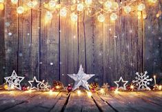 a wooden table topped with snowflakes and christmas lights next to a star on top of it