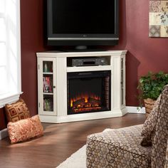 a living room with a television and fire place in the corner, along with a chair