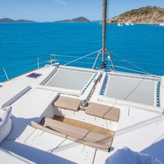 the deck of a sailboat with lounge chairs on it