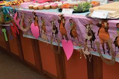 there is a table that has some food on it and paper decorations hanging from the tables