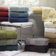 towels are stacked on a rack in front of a window