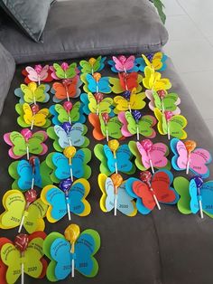 many colorful butterfly shaped lollipops are on the floor next to a couch