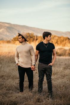 two men standing in the middle of a field