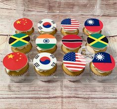 cupcakes decorated with flags are displayed on a table