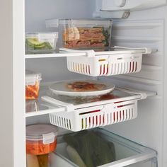 an open refrigerator with food in it and plastic containers on the bottom shelf, including salad